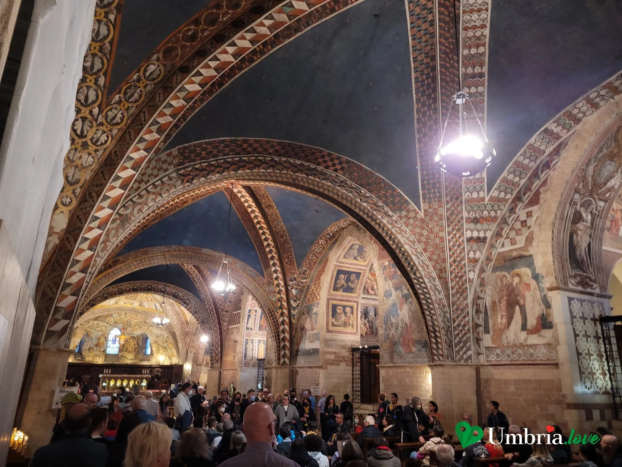 L'interno della Basilica Inferiore di San Francesco ad Assisi: le volte gotiche basse interamente coperte di affreschi