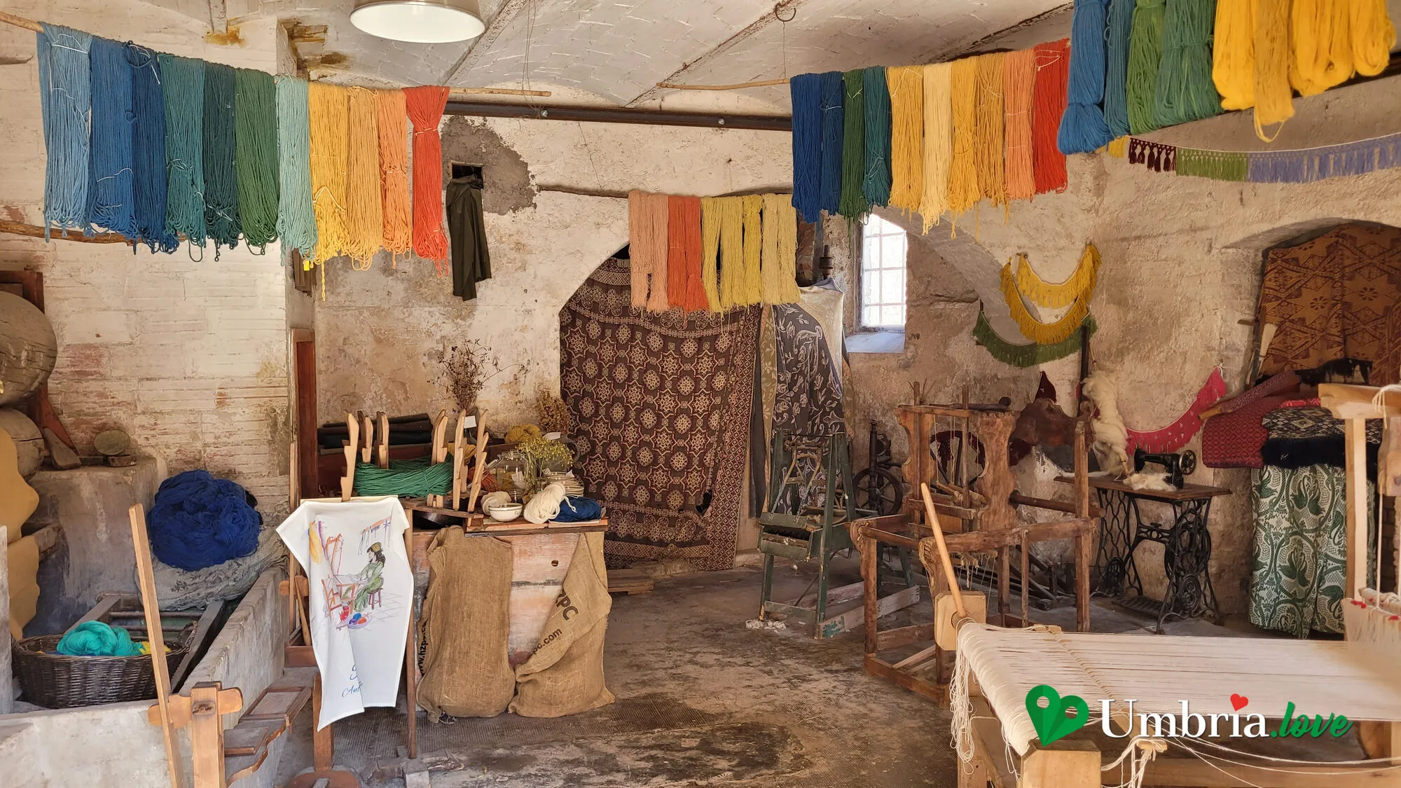 La bottega tessile di Rasiglia: matasse di lana colorata appese e gli attrezzi di lavoro