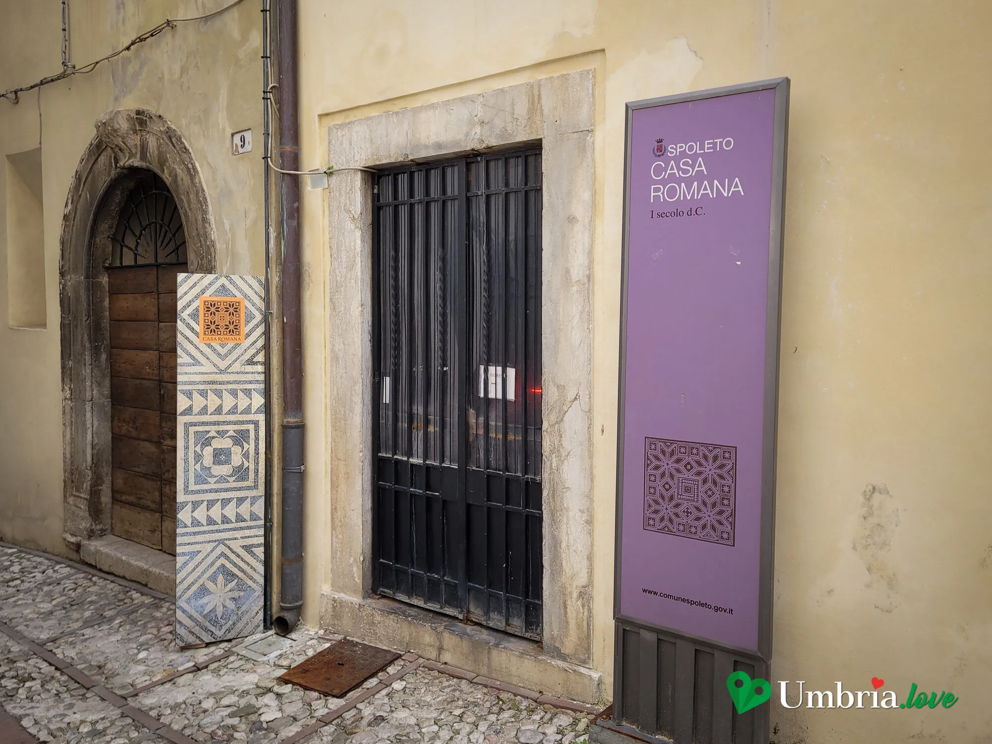 L'ingresso della Casa Romana di Spoleto, con un pannello a intarsi geometrici accanto al portale