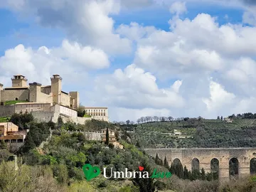La Rocca Albornoziana sul colle di Spoleto e, sulla destra, le arcate del Ponte delle Torri sopra la gola boscosa del Monteluco