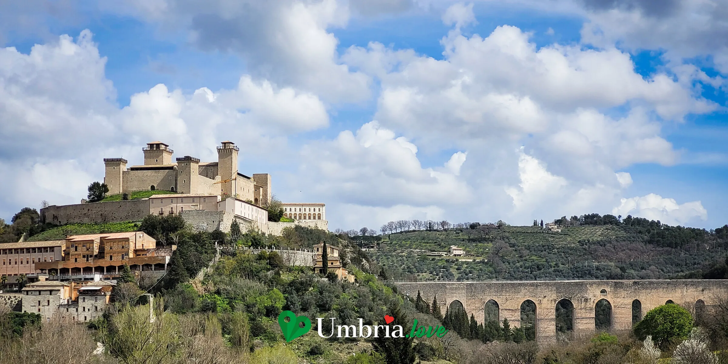 La Rocca Albornoziana sul colle di Spoleto e, sulla destra, le arcate del Ponte delle Torri sopra la gola boscosa del Monteluco