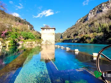 La torretta e la vecchia chiusa della sorgente della Morìca si specchiano nell'acqua turchese del Nera, lungo le Gole del Nera