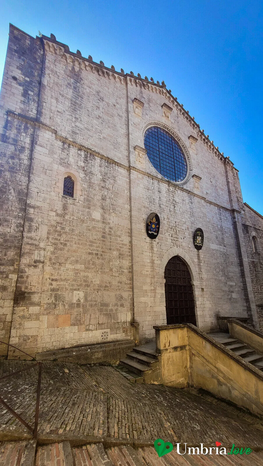 La facciata del Duomo di Gubbio con il rosone e i simboli degli evangelisti