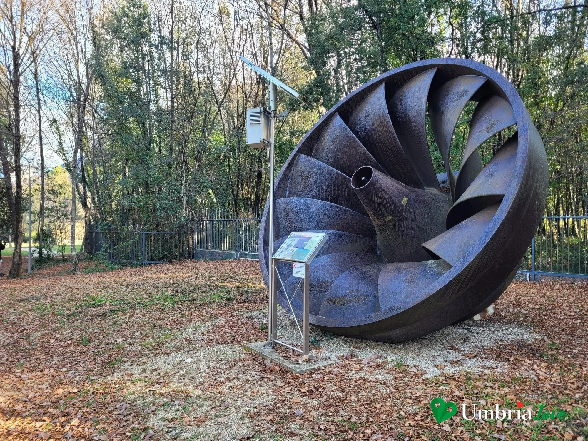 Una grande turbina idraulica dismessa esposta nel prato del giardino-museo