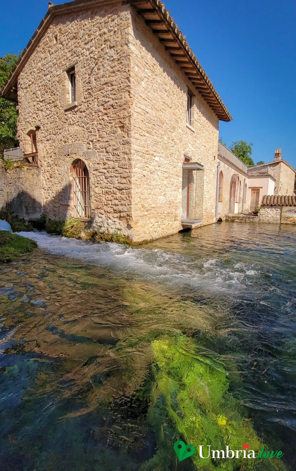 Una casa-mulino di Rasiglia con l'acqua che esce e scorre sui ciottoli davanti alla porta