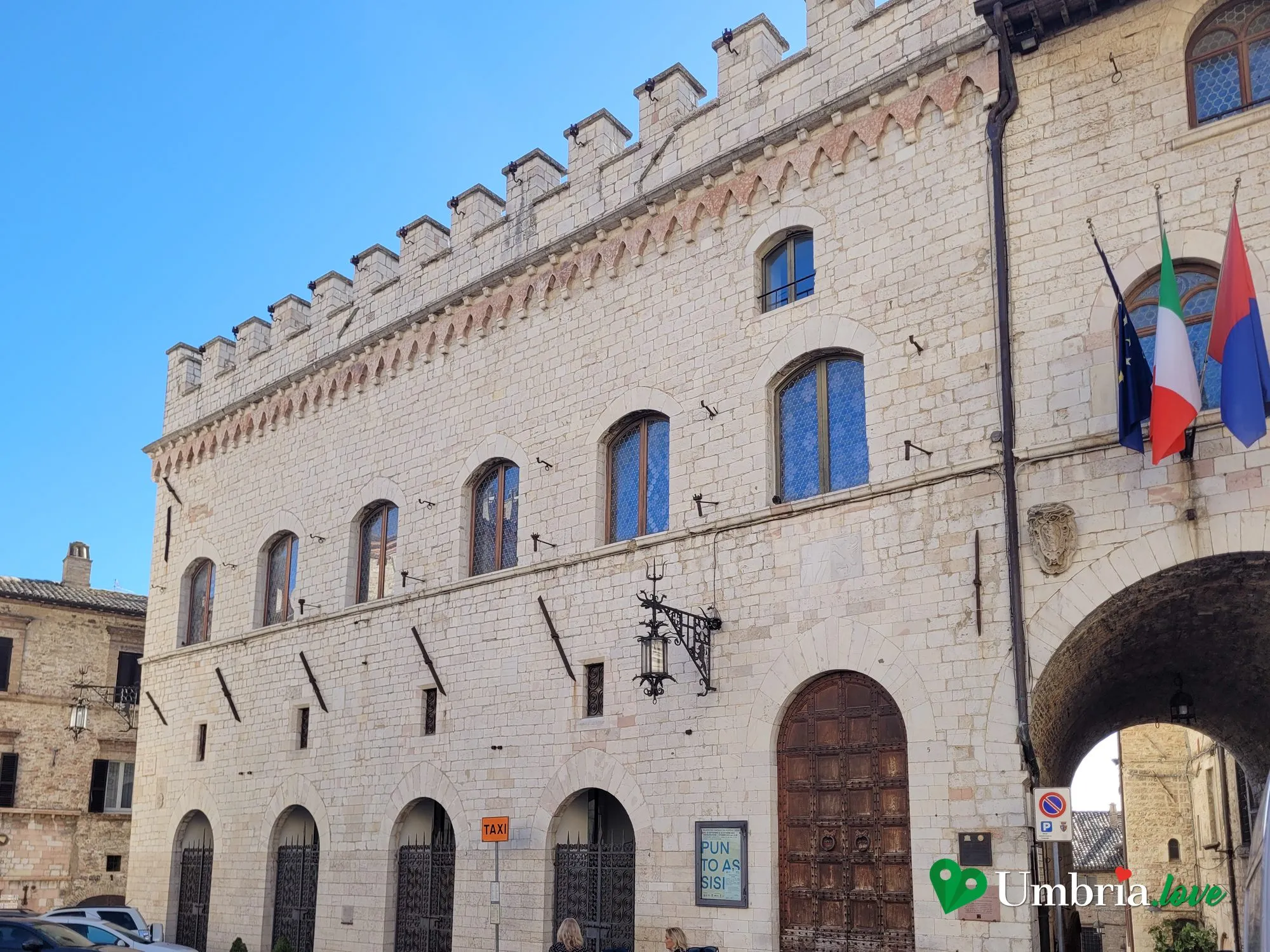 Il Palazzo dei Priori ad Assisi, con la lunga facciata e la merlatura guelfa, sulla Piazza del Comune