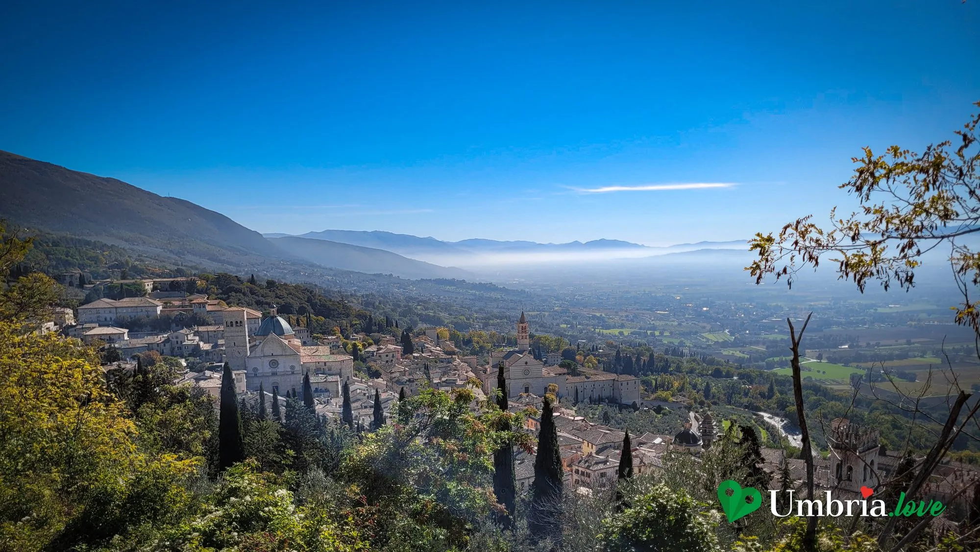 Il panorama sulla Valle Umbra da Assisi, con gli ulivi in primo piano e la pianura nella foschia