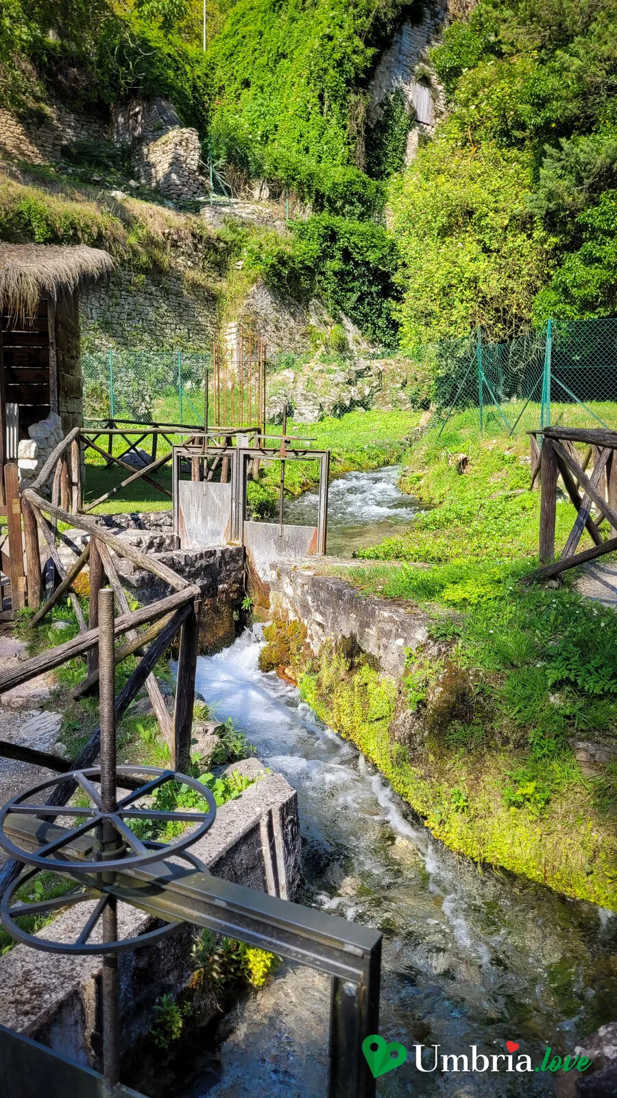 Paratoie e canalette di legno su un pendio erboso di Rasiglia, per dirottare l'acqua verso le macchine
