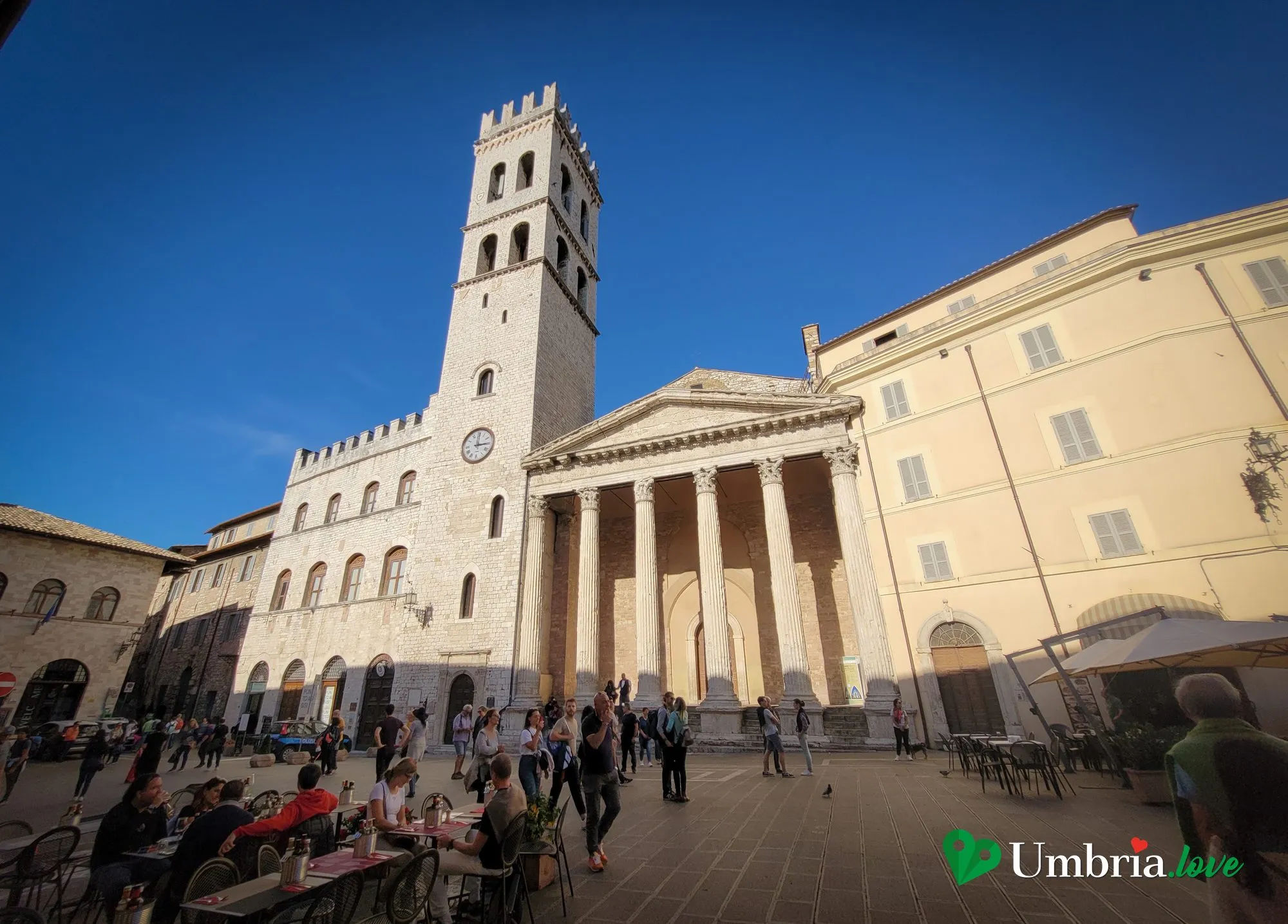 Piazza del Comune ad Assisi vista in larghezza, con il Palazzo del Capitano del Popolo, la Torre del Popolo e il portico del Tempio di Minerva