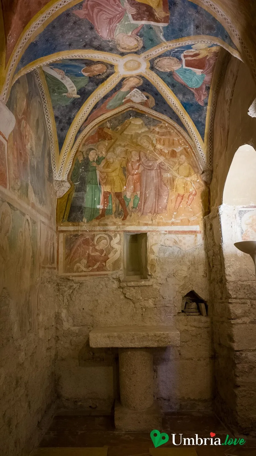 Una campata affrescata di Santa Maria di Pietrarossa, con un altare in pietra