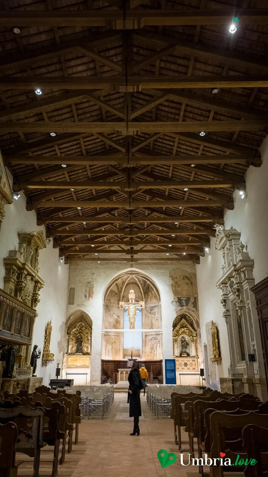 L'interno della chiesa di San Francesco a Trevi: navata unica, tetto a capriate e il Crocifisso dipinto sull'abside