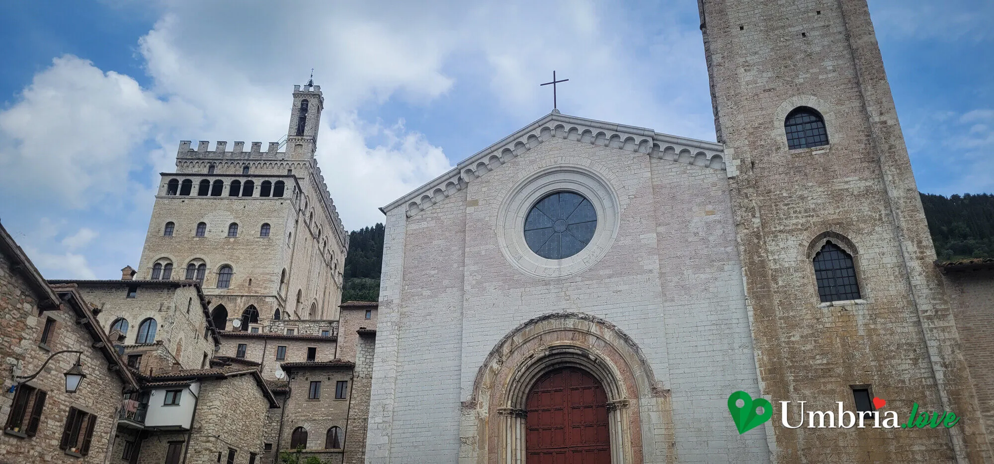 La chiesa di San Francesco a Gubbio vista da Piazza Quaranta Martiri, con il Palazzo dei Consoli e il Palazzo Ducale che dominano dall'alto