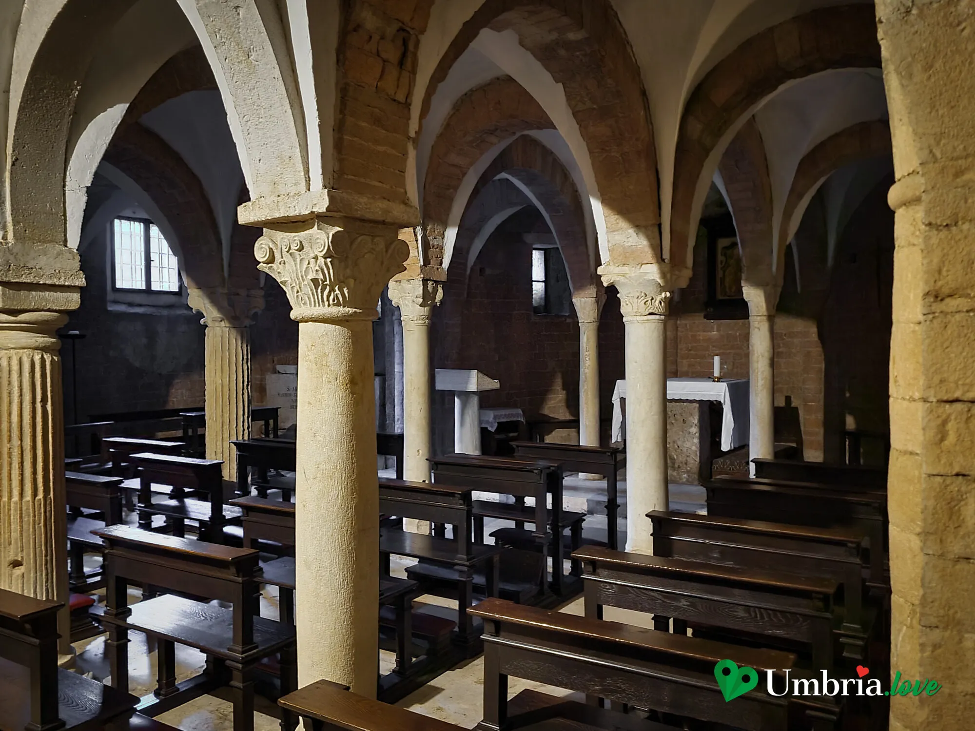 L'interno romanico di San Gregorio Maggiore a Spoleto: le tre navate, il presbiterio rialzato e il soffitto a capriate