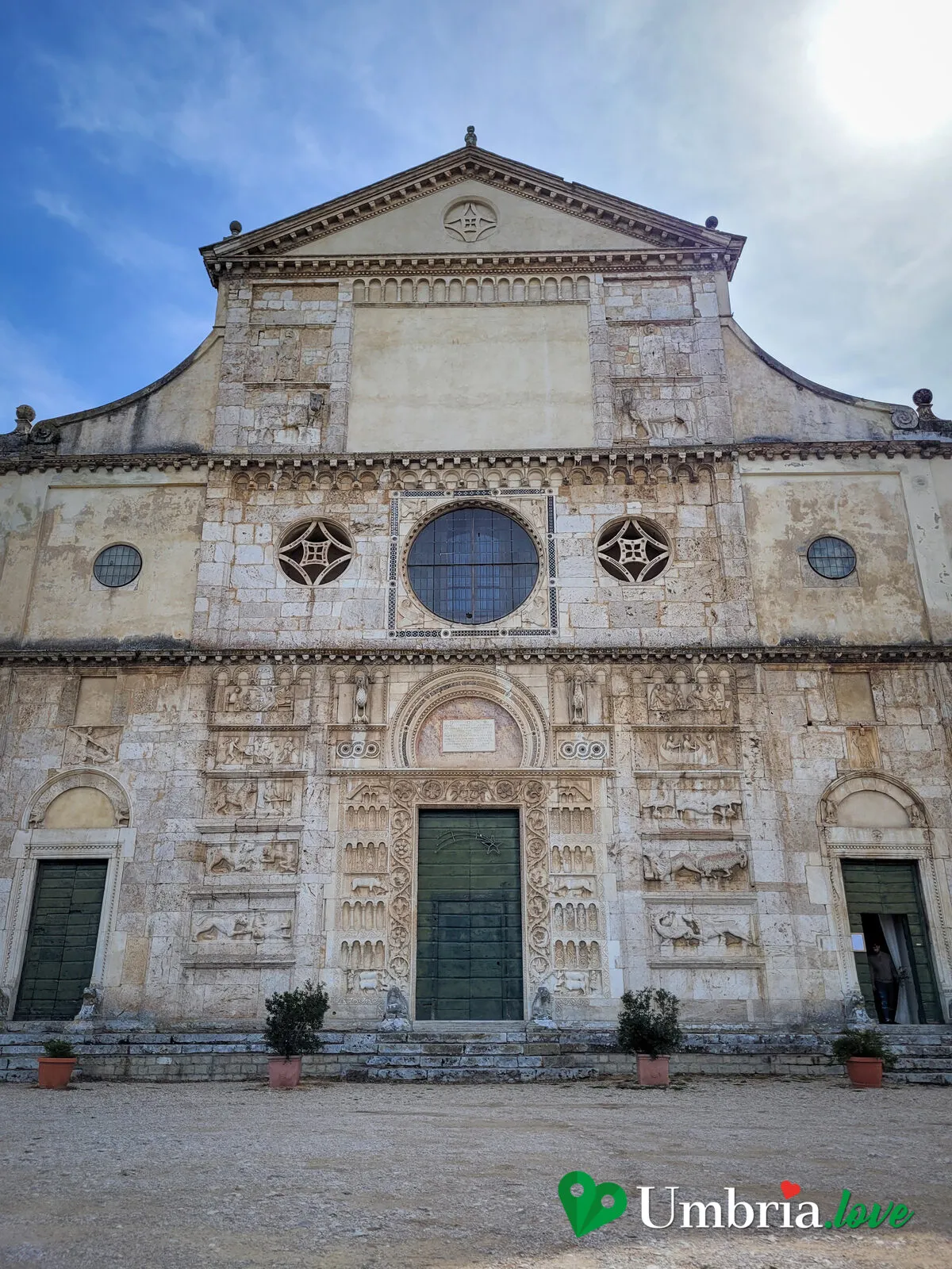 La facciata romanica scolpita di San Pietro extra moenia a Spoleto, in cima alla scalinata, di fronte alla città
