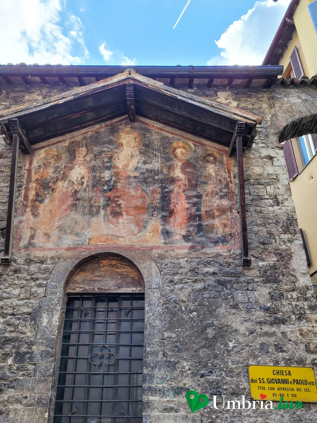 La facciata in pietra della chiesa dei Santi Giovanni e Paolo a Spoleto, con l'affresco esterno nella lunetta del timpano