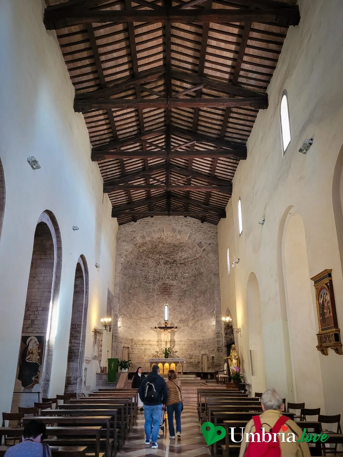 L'interno romanico del Santuario della Spogliazione ad Assisi, a navata unica, con le pareti chiare e qualche affresco