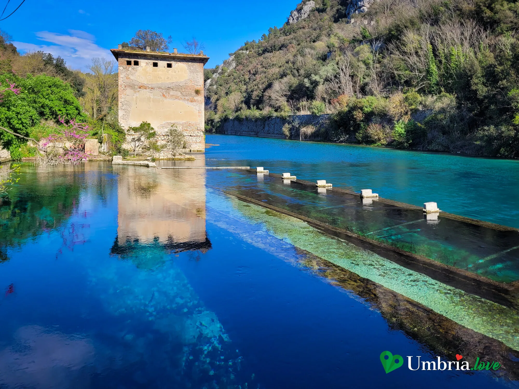 La chiusa e la torretta della sorgente della Morìca, sul Nera turchese, coi passi di pietra sull'acqua